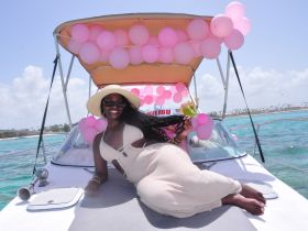 A joyful moment on a boat adorned with pink balloons, capturing the essence of a festive celebration on the water.