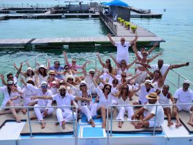 A vibrant group of friends celebrates together on a boat, showcasing joy and camaraderie against a beautiful waterfront backdrop — perfect for memorable gatherings and events.
