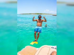 A snorkeler gives a thumbs up while preparing to dive into the vibrant turquoise waters, showcasing the excitement of underwater adventures.