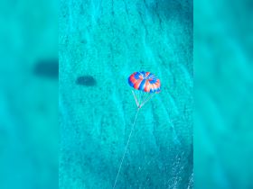 A thrilling parasailing adventure over stunning turquoise waters, showcasing the excitement of water sports and breathtaking aerial views.