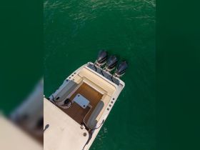 Aerial view of a sleek boat showcasing its powerful outboard motors and stylish deck, perfect for thrilling water adventures.