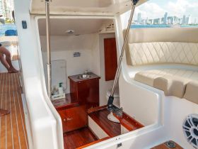 Inside view of a boat's cabin featuring a bathroom area and comfortable seating, ideal for relaxation during trips on the water.