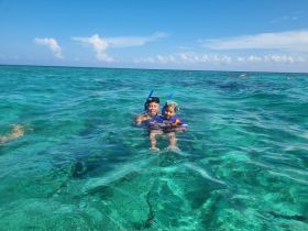 A joyful family enjoys snorkeling in crystal-clear waters, creating unforgettable memories while exploring the underwater world.