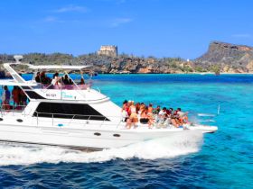 A lively group enjoys a day on the water aboard a yacht, celebrating against a stunning ocean backdrop — perfect for unforgettable boat parties.