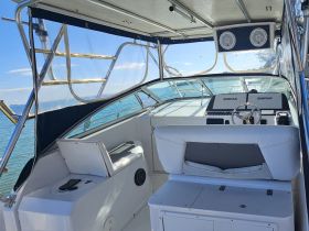 The interior view of a boat's helm showcases the seating and control console, perfect for navigating the waters in comfort.