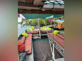 Cozy interior of a boat featuring colorful cushions and a relaxed seating area, perfect for lounging while enjoying the scenic views of the surrounding mangroves.