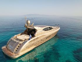 A stunning aerial view of a luxurious yacht named 'Zeus' anchored in crystal-clear waters, showcasing its sleek design and elegance.