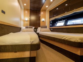 A cozy interior view of a boat cabin featuring twin beds, perfect for restful nights on the water.