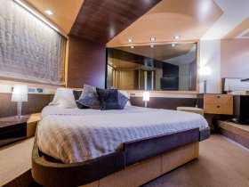 A cozy and modern cabin interior featuring a comfortable bed and stylish decor, perfect for relaxing on a boat getaway.