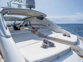 The luxurious interior of a yacht features spacious lounge seating with plush cushions, perfect for relaxing while enjoying the ocean views.