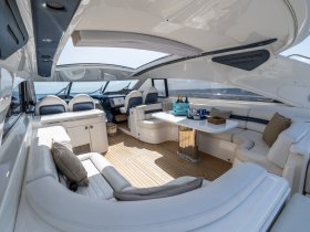 A luxurious interior view of a yacht's cabin featuring comfortable seating and a well-equipped helm, perfect for relaxing while cruising on the water.