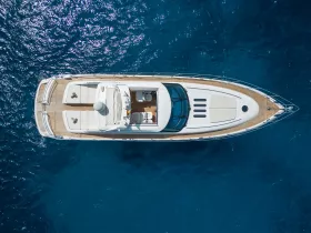 A stunning aerial view of a luxurious yacht cruising through deep blue waters, showcasing its elegant design and spacious deck.