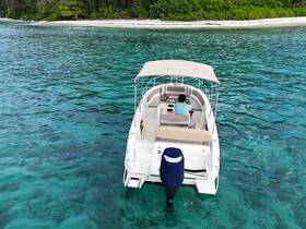 An aerial view of a boat navigating through crystal-clear waters, showcasing a serene tropical setting perfect for exploration and adventure.