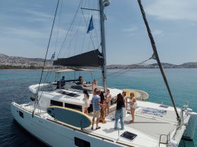 A lively group enjoys a day on a yacht, celebrating with drinks and sunbathing on the deck — perfect for summer outings and gatherings on the water.