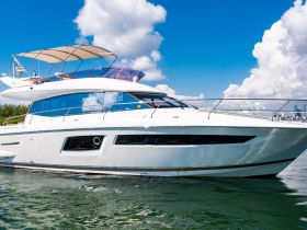 A stunning view of a Prestige 500 yacht cruising through clear waters, showcasing its elegant design and luxurious features.