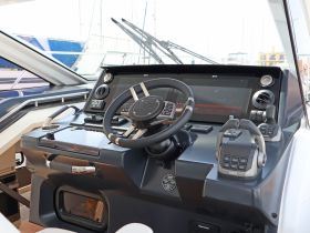 A detailed view of a modern boat helm showcasing advanced navigation controls and instrumentation, perfect for steering and managing onboard systems.