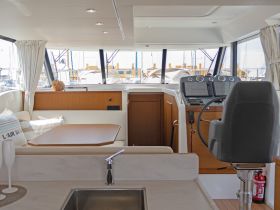 A well-appointed interior view of a yacht's helm and seating area, showcasing modern design and comfort for an enjoyable boating experience.