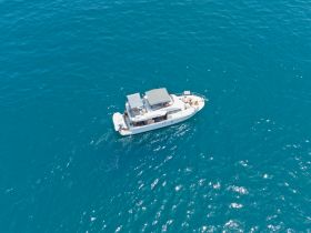 Aerial view of a sleek yacht cruising through vibrant turquoise waters, perfect for luxury charters and ocean adventures.