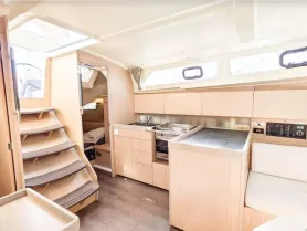 A spacious and modern interior of a boat featuring a well-equipped kitchen and comfortable seating area, perfect for relaxing during your nautical adventures.