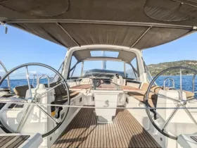 A well-appointed helm area inside a sailboat, featuring spacious seating and modern controls, perfect for navigating the open waters.