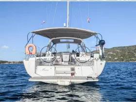 A stunning view of the back of the yacht 'Marie' cruising through clear waters, showcasing its sleek design and tranquil surroundings.