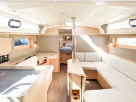 A bright and modern interior of a boat cabin featuring comfortable seating and a well-equipped helm area, perfect for relaxing during your nautical adventures.