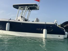 A sleek Robalo boat captured from the side, showcasing its elegant design against a backdrop of clear turquoise waters.