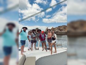 A lively group dressed in pirate costumes enjoys a fun-themed party on a boat, showcasing a memorable celebration against a scenic backdrop.