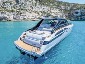 A stunning view of a luxury yacht named 'Make My Day' cruising through crystal-clear waters, surrounded by picturesque cliffs — perfect for showcasing elegant boating experiences.