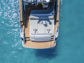 Aerial view of a sleek boat showcasing its spacious deck and luxurious seating, perfect for enjoying the open waters.