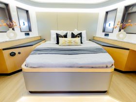 A beautifully designed cabin featuring a cozy bed and elegant decor, perfect for relaxing on a luxury boat.