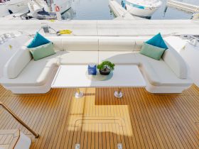 A stylish lounge area on a yacht featuring comfortable seating and a chic table, perfect for relaxing and enjoying the views while on the water.