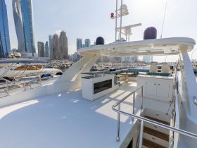 A spacious and elegantly designed interior of a yacht, featuring comfortable seating and a well-equipped helm, perfect for luxury cruising in urban marinas.