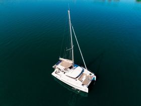 A stunning aerial view of a sleek catamaran gliding through calm waters, perfect for luxury sailing adventures and island hopping.