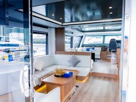 A modern and spacious interior of a yacht featuring comfortable seating and a well-equipped helm, perfect for relaxing and navigating on the water.