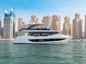 A stunning side view of a luxury yacht cruising through clear waters, with a backdrop of modern skyscrapers, perfect for showcasing upscale boating experiences.