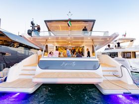 Guests gather on the luxurious deck of the yacht 'Infinity,' enjoying a vibrant atmosphere and dining experience — perfect for celebrations and social gatherings on the water.