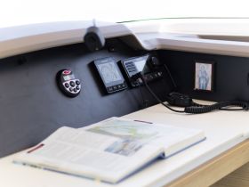 A detailed view of the helm area inside a boat, showcasing the control console and navigation equipment — essential for any boating adventure.