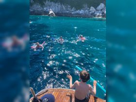 A joyful scene of a family enjoying a day of swimming and snorkeling in crystal-clear waters, with children and adults having fun together.