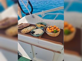 A beautifully arranged spread of charcuterie and fresh fruits on a boat, perfect for enjoying a delightful snack while cruising on the water.