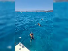 A group enjoys snorkeling in crystal-clear waters, showcasing the vibrant marine life and stunning scenery — a perfect adventure for water enthusiasts.