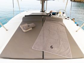A cozy lounging area on a catamaran featuring neatly arranged towels, perfect for relaxing under the sun while enjoying the serene waters.