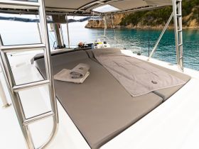 A cozy lounge area on a catamaran, featuring plush seating and towels, perfect for relaxing while enjoying the serene waters.