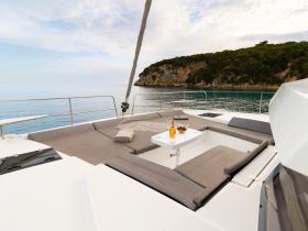 A cozy lounge area on a catamaran, featuring comfortable seating and refreshments, perfect for relaxing while enjoying the serene coastal views.