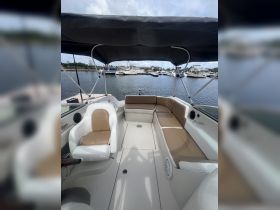 Interior view of a spacious boat cabin featuring comfortable seating and a helm, perfect for relaxing on the water.