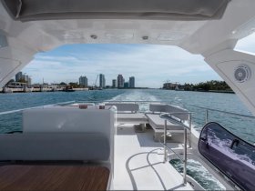A sleek interior view of a boat's helm and seating area, showcasing modern design and comfort while cruising through scenic waters.
