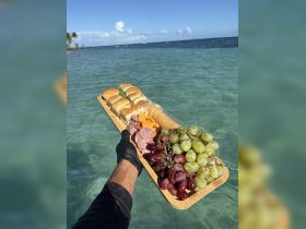 A beautifully arranged platter of sandwiches, cheeses, and grapes, perfect for enjoying on the water. Ideal for catering on boat trips or beach picnics.