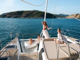 A group of friends enjoys a sunny day on a yacht, showcasing a fun and stylish atmosphere perfect for celebrations and relaxation on the water.