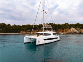 A stunning aerial view of a Bali catamaran anchored in tranquil waters, surrounded by lush greenery — perfect for luxurious sailing adventures.