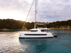A stunning catamaran anchored in tranquil waters, surrounded by lush greenery — perfect for exploring coastal destinations.